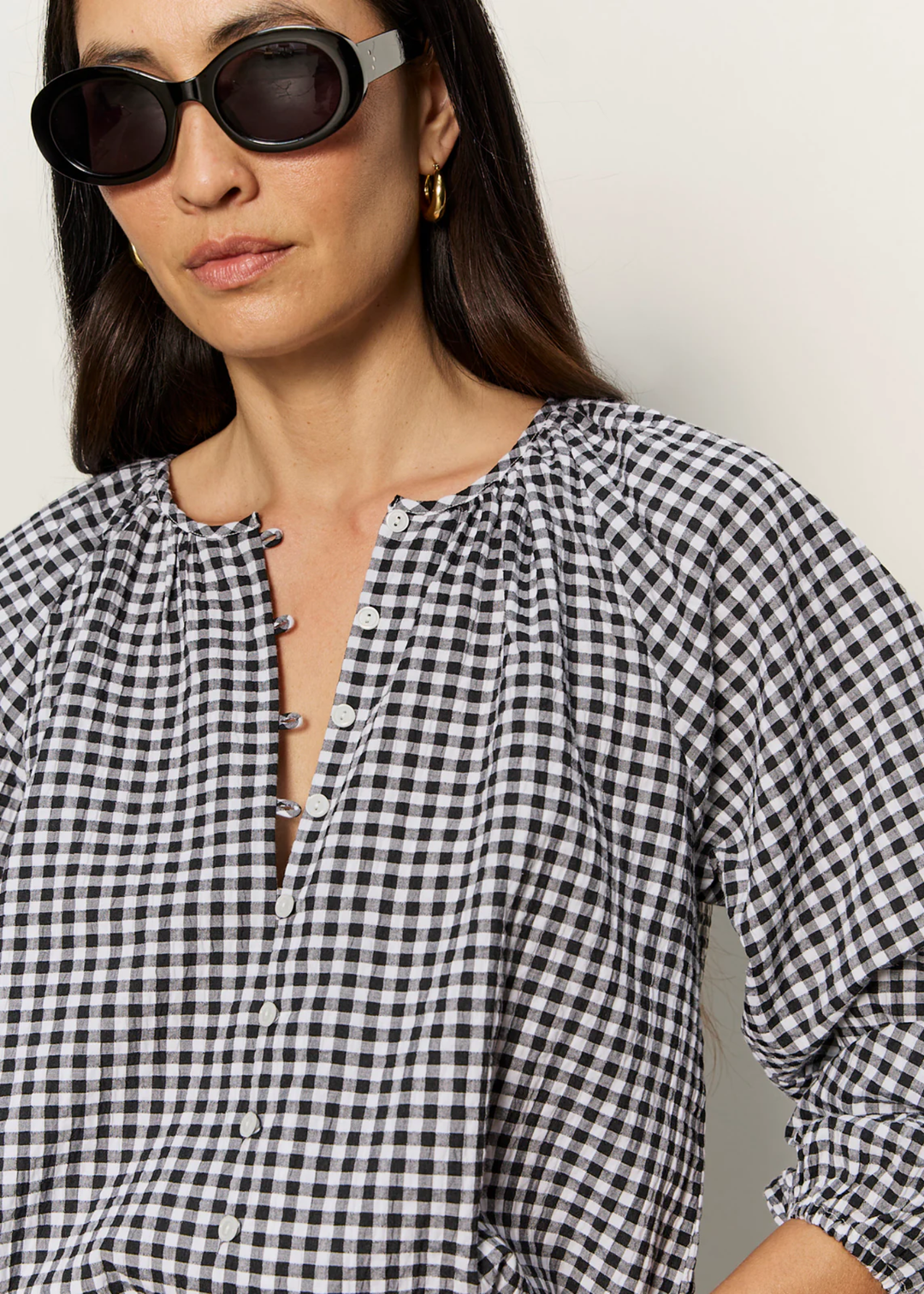 Close up of a woman wearing a black and white gingham top