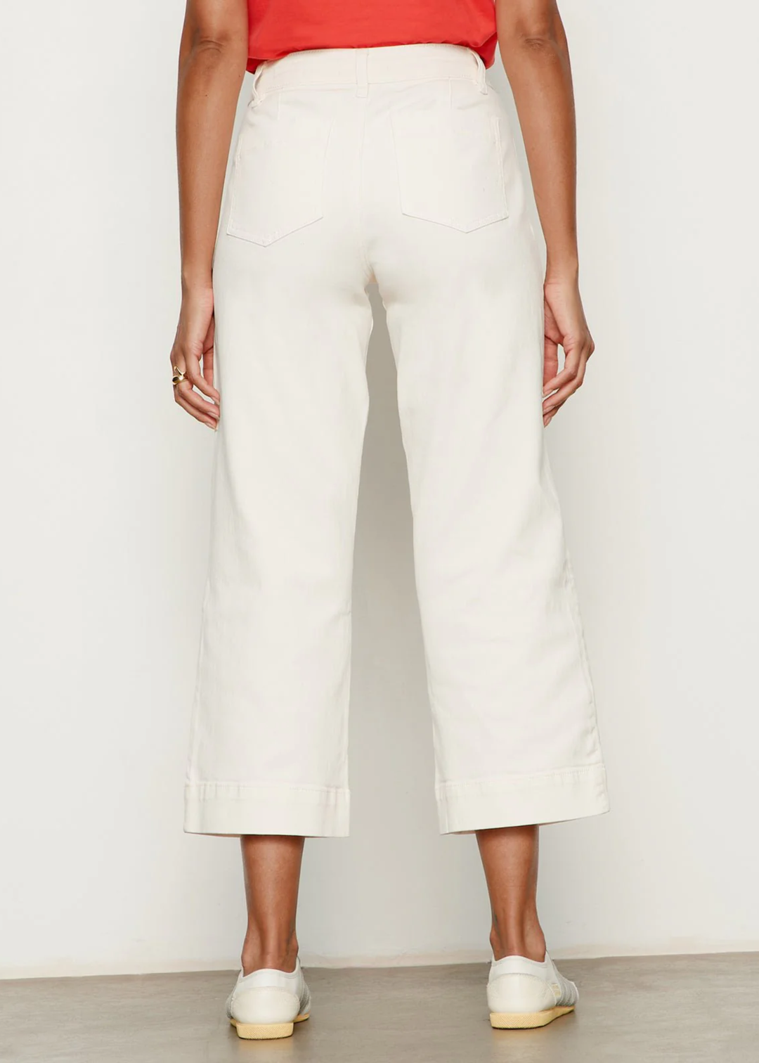 Woman turned around wearing a very light pink jean with a red t-shirt