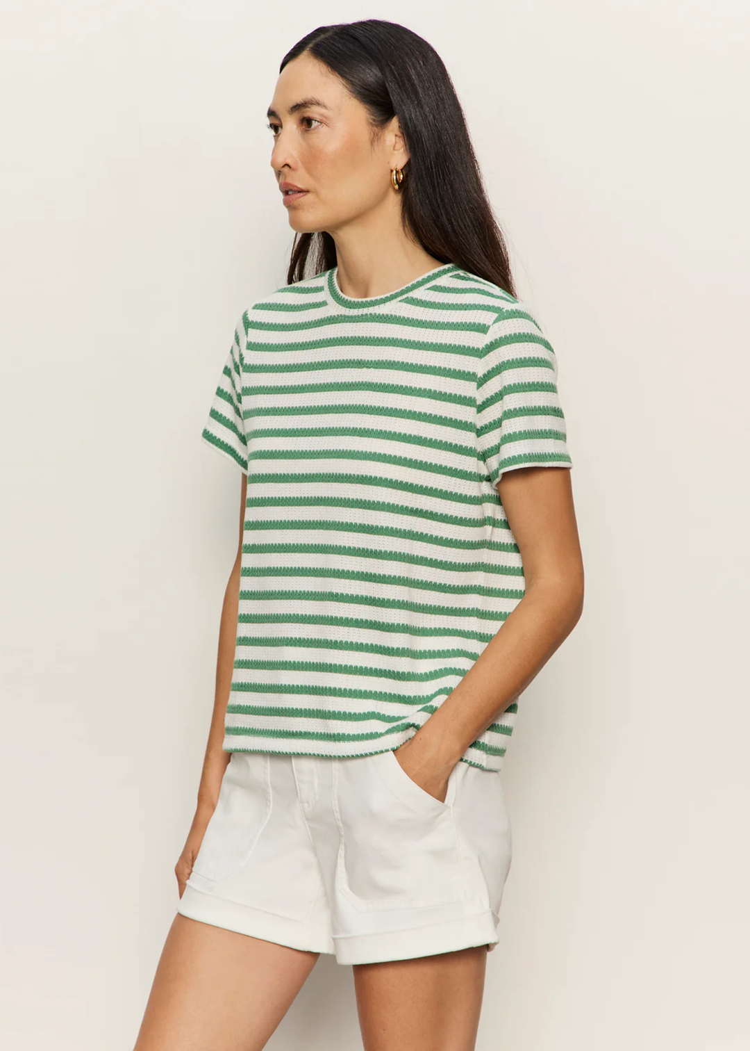 Woman wearing a green and white striped t-shirt with white shorts
