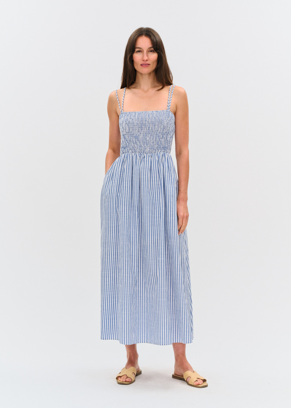 Woman wearing a blue and white striped maxi dress with sandals