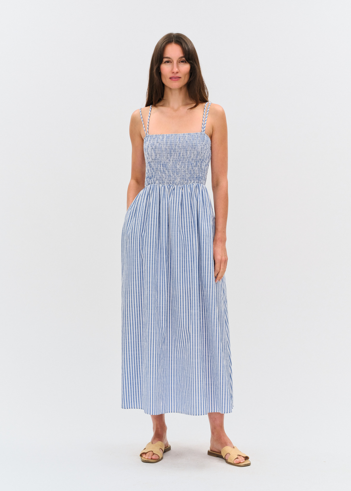 Woman wearing a blue and white striped maxi dress with sandals
