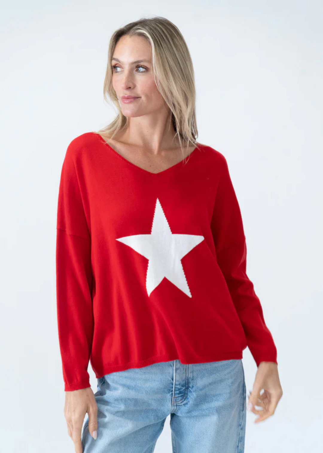woman wearing red scoop neck sweater with white star on chest