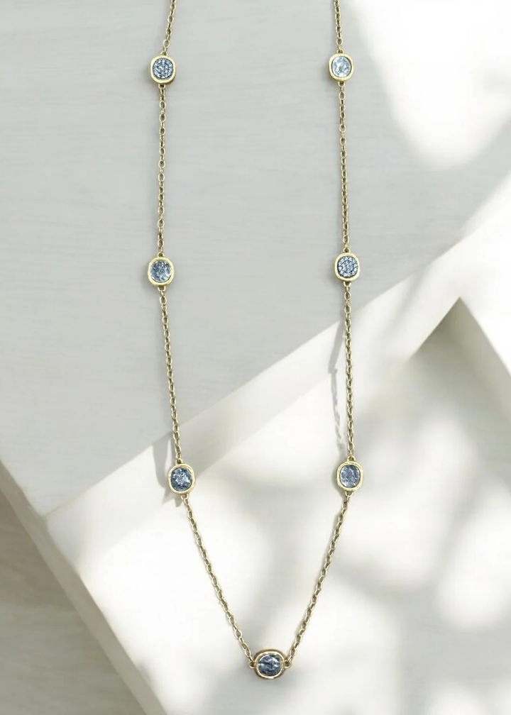 Gold chain necklace with silver coins on a white background