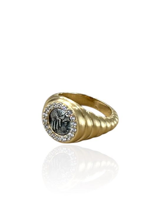 Gold scalloped ring with a silver coin framed in CZ's on a white background
