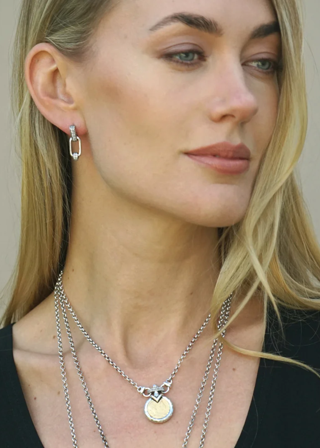Woman wearing a vintage silver chain necklace with a gold coin