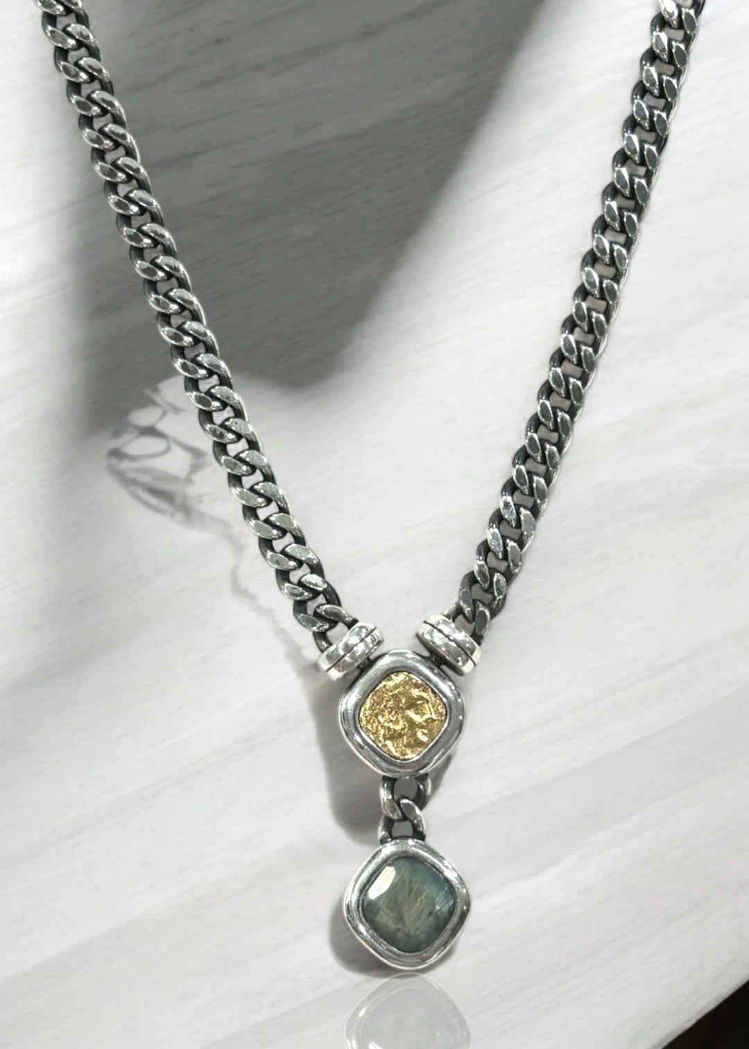 Vintage silver chain necklace with a gold coin and labradorite pendant on a white background