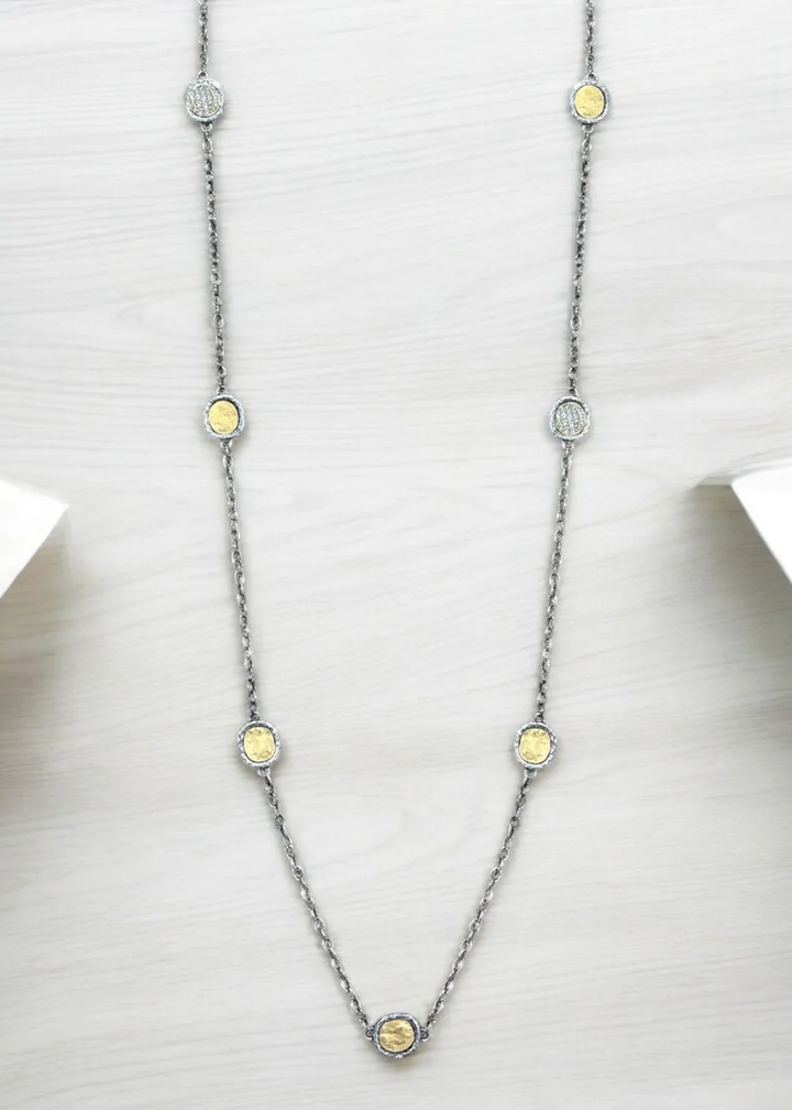 Silver chain necklace with gold coins on a white background