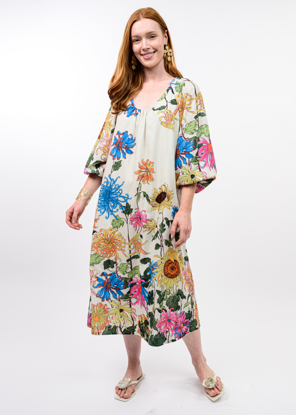 Woman wearing an ivory midi dress with a bright floral print
