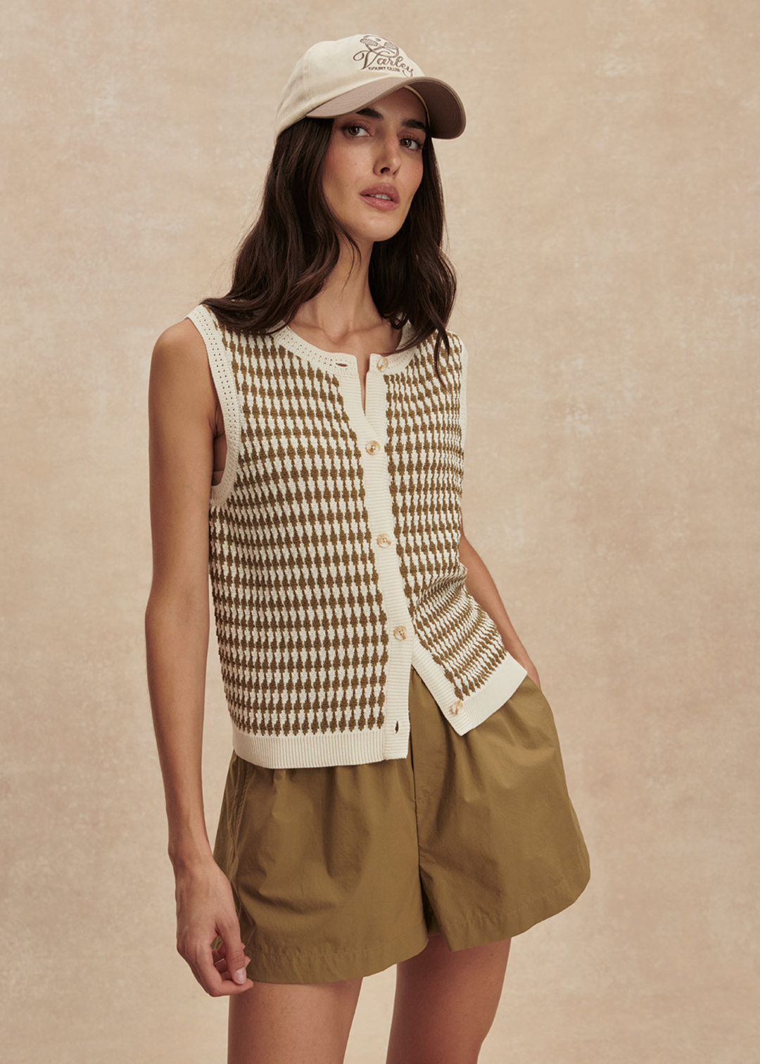 Woman wearing a brown and white knit button up tank top with matching brown shorts