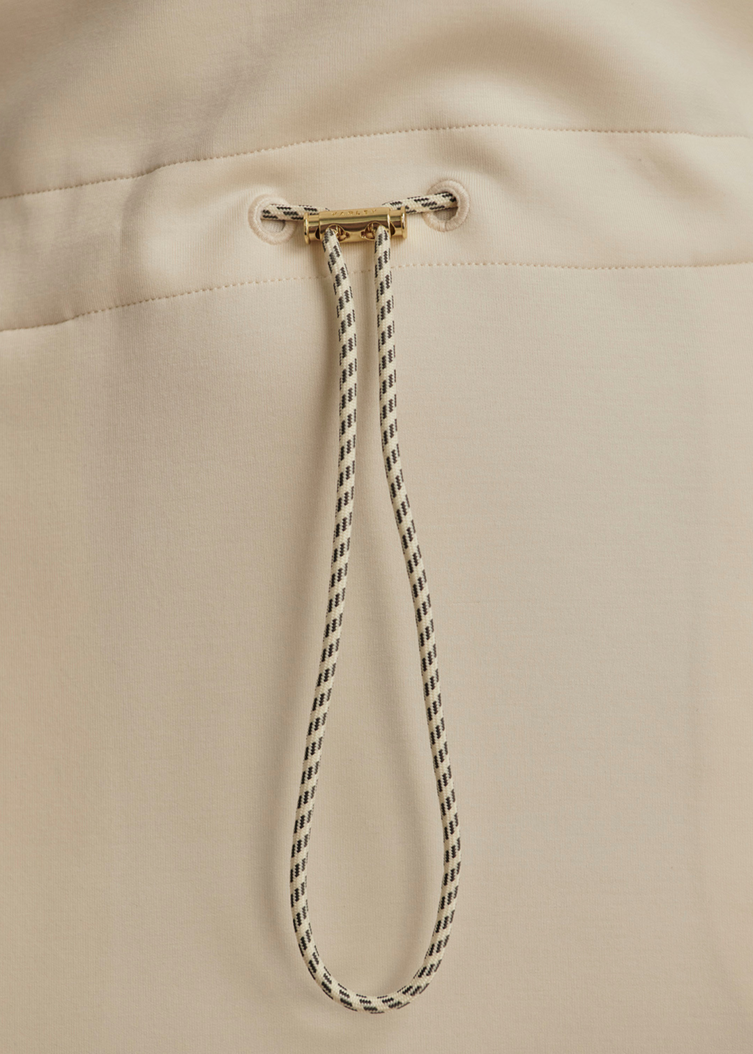 Close up of a cinched waist of an ivory mini dress
