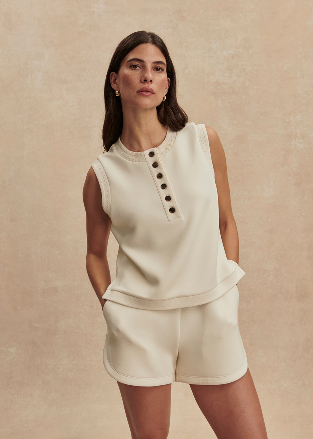 Woman wearing an ivory button tank top with matching shorts