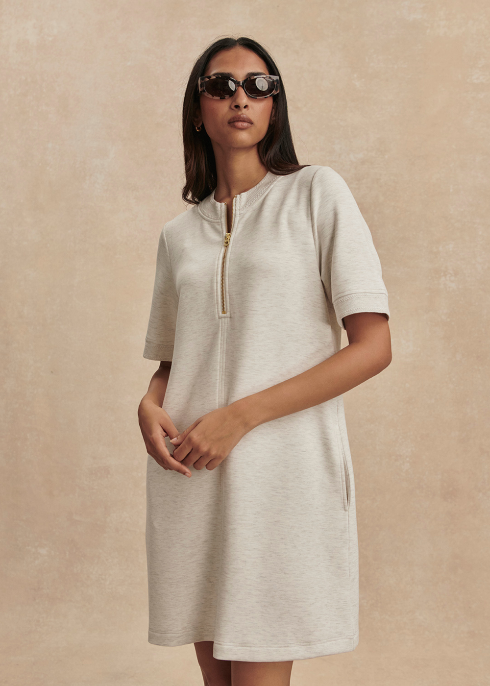 Woman wearing an ivory half zip mini dress