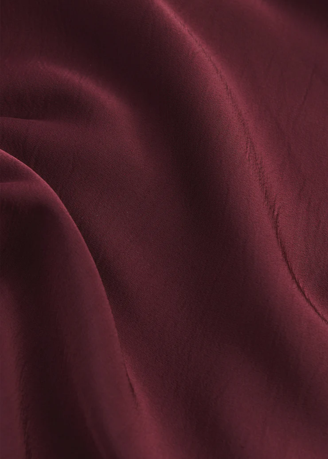 Close up of a maroon satin mini skirt