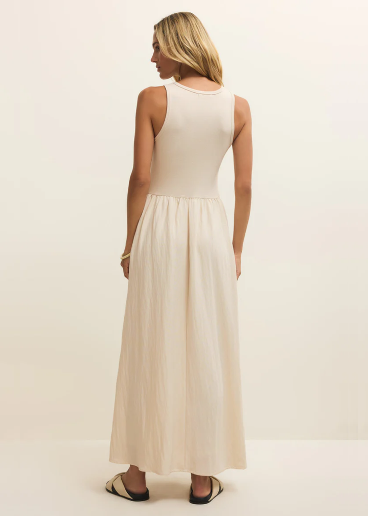 Woman turned around wearing a white midi dress and sandals