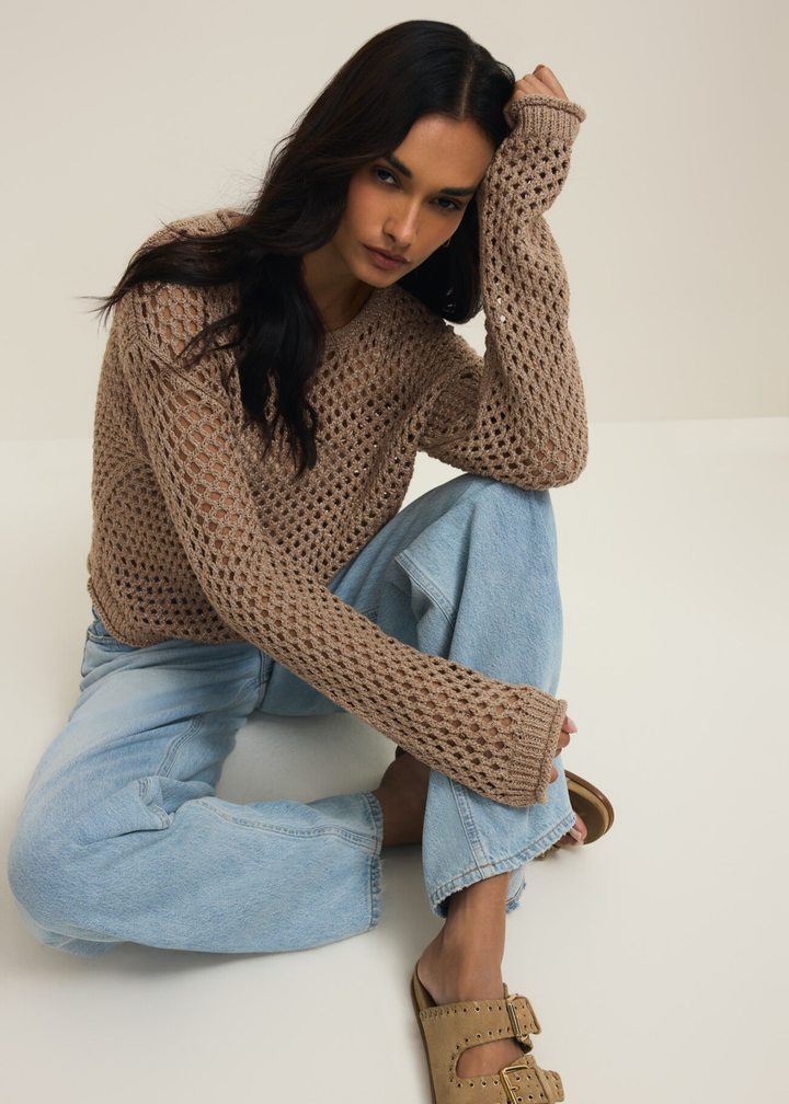 Woman wearing a brown shimmer sweater with jeans