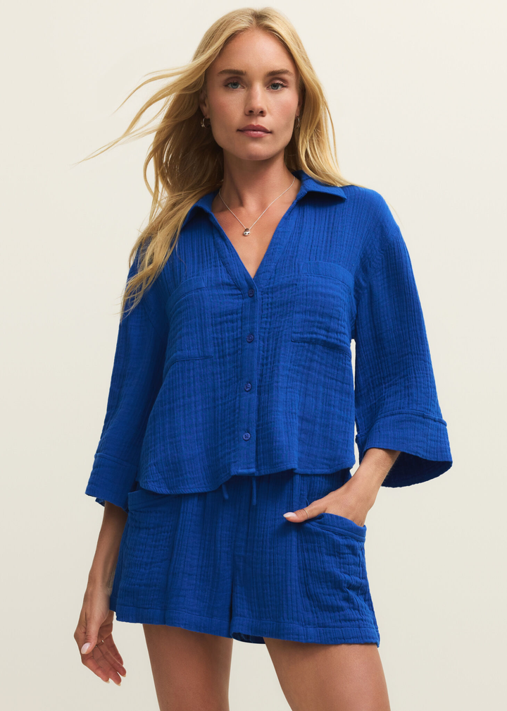 Woman wearing a blue button down with matching shorts