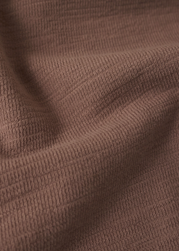 Close up of a brown textured knit fabric