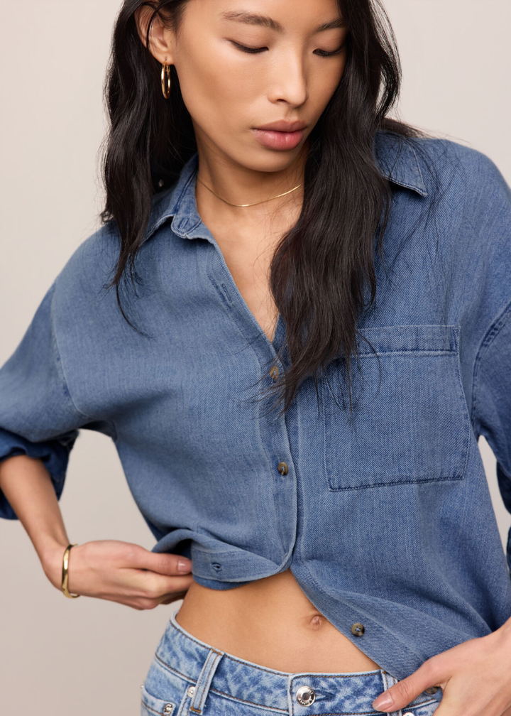 Woman wearing a denim button down top and jeans