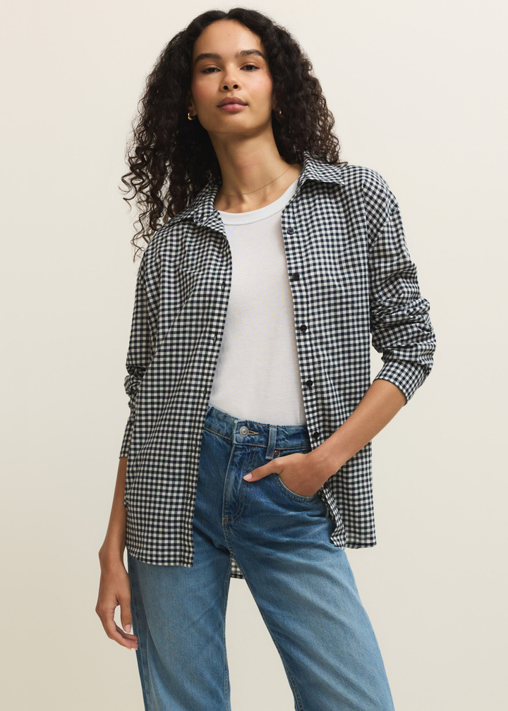 Woman wearing a navy and white gingham button down over a white t-shirt with jeans