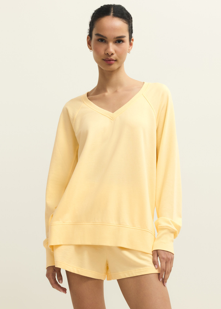 Woman wearing a yellow v-neck sweatshirt with yellow shorts