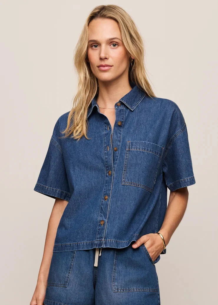 Woman wearing a blue denim outfit on a beige background