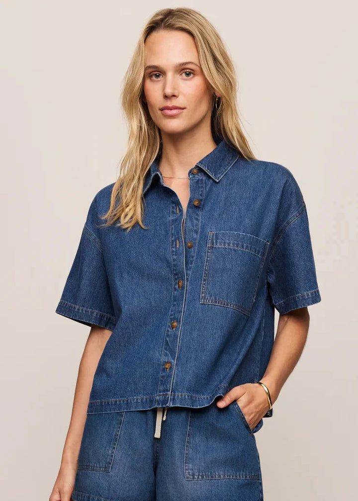 Woman wearing a blue denim outfit on a beige background