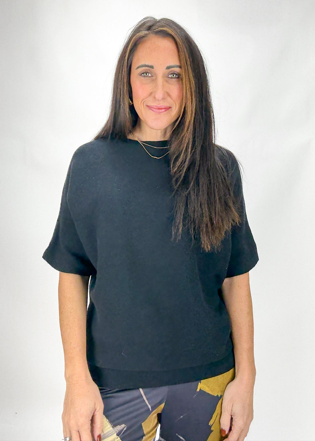 Woman wearing a black oversized t-shirt against a white background