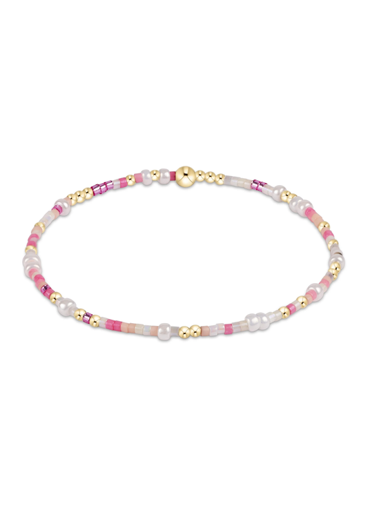 Pink, white, and gold beaded bracelet on a white background