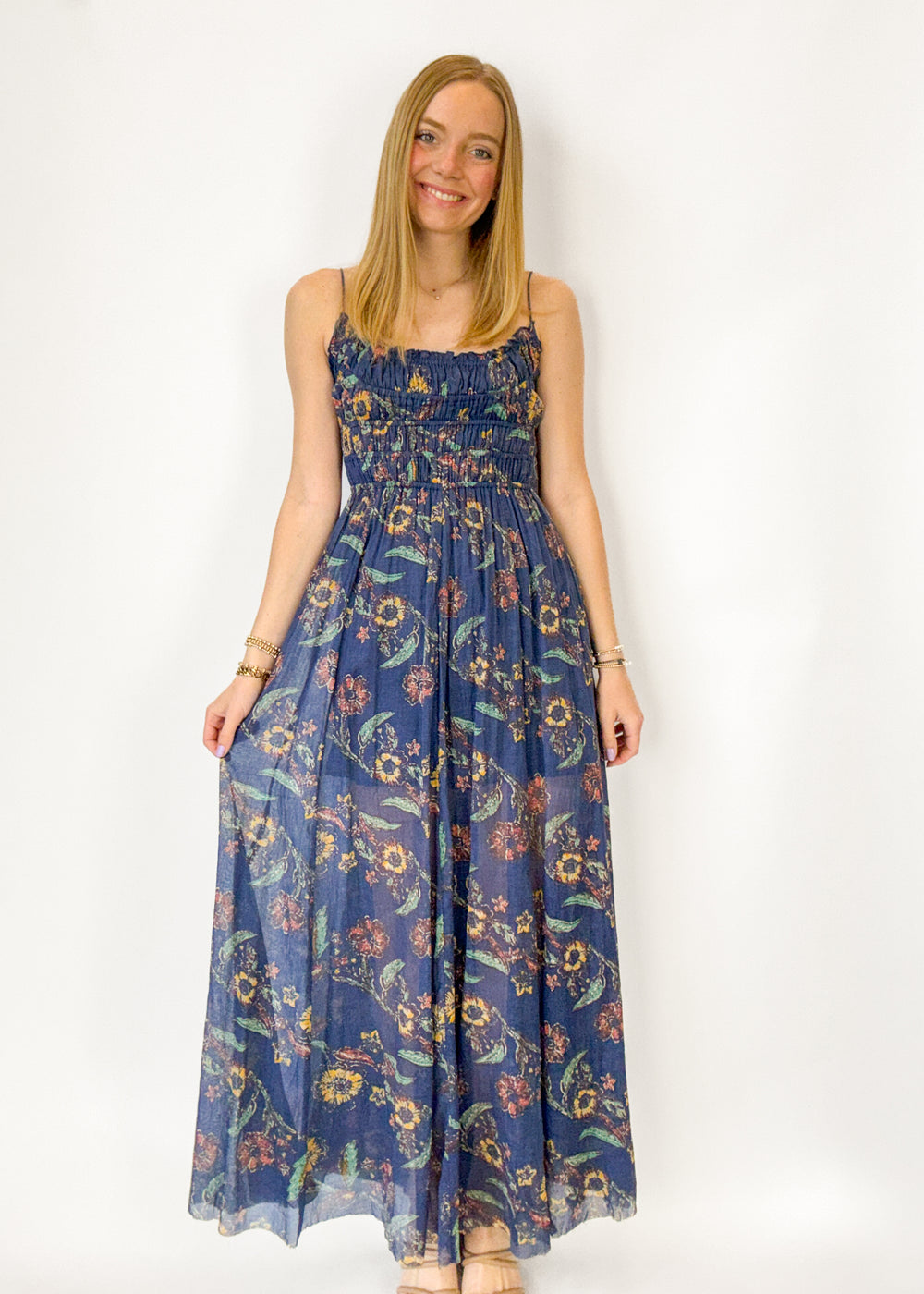 Woman wearing a blue floral dress against a white background