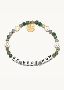 green crystal beads with smiley face bead accents and square letter beads that read "be here now"