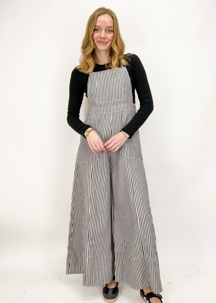 Woman wearing a black and white striped dress against a white background