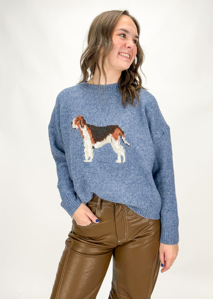 Woman wearing a blue sweater with a dog design on a white background