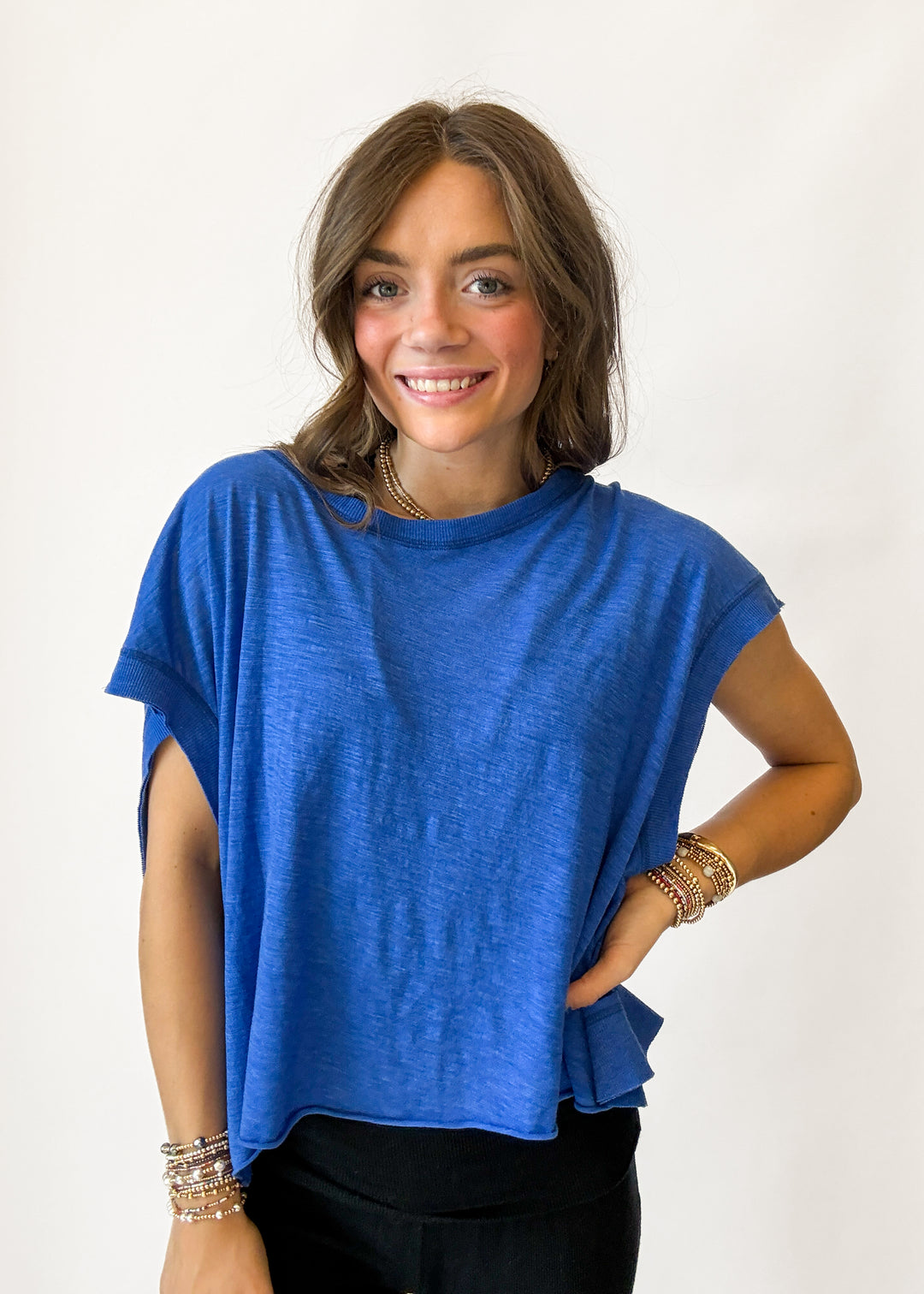 Woman wearing a blue top with a plain background