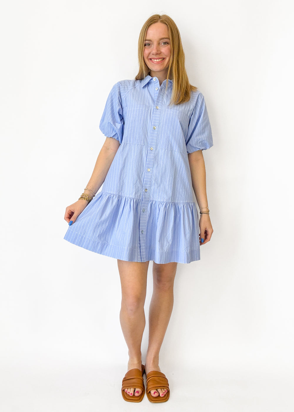 Woman wearing a blue striped dress against a white background
