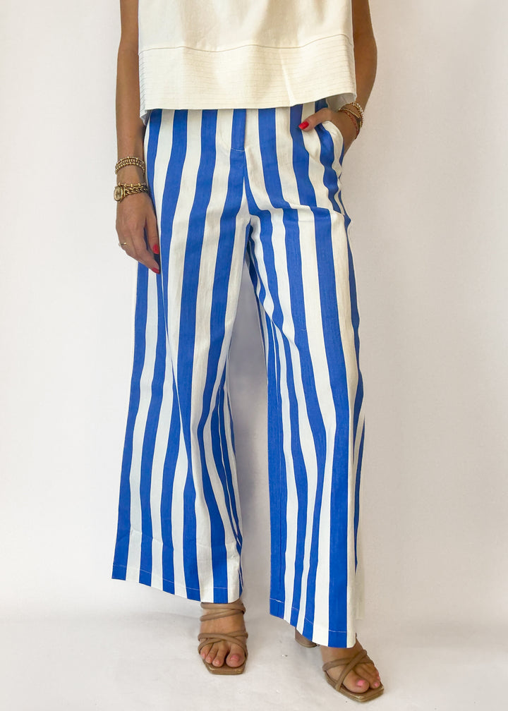 Person wearing blue and white striped pants on a plain background