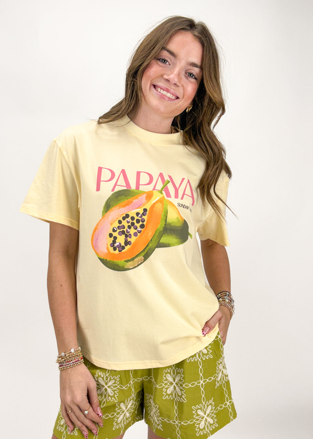 Woman wearing a yellow t-shirt with a papaya graphic and 'Papaya' text on a white background