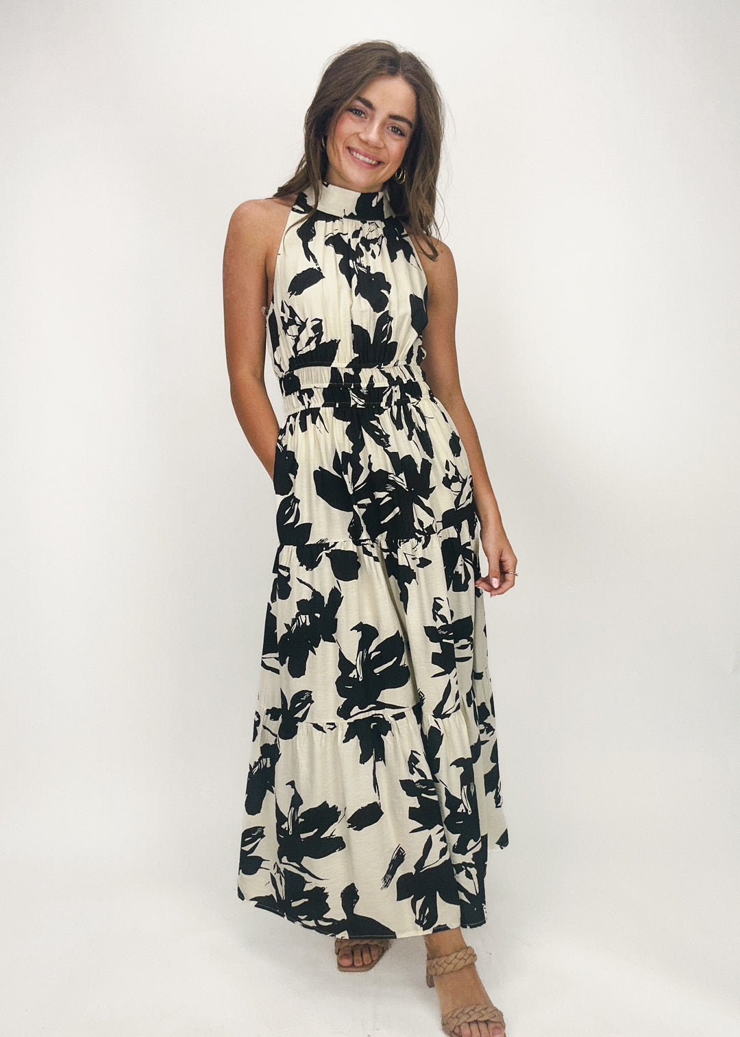 black and cream floral maxi dress with elastic waist, tiered skirt, and halter tie neck