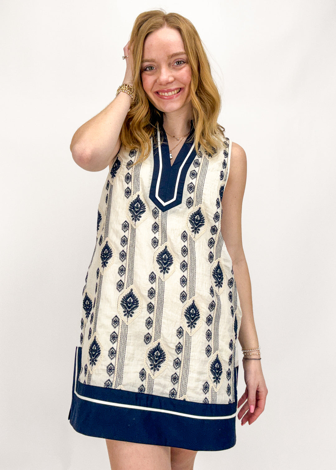 Woman wearing a sleeveless dress with a blue and white pattern on a white background