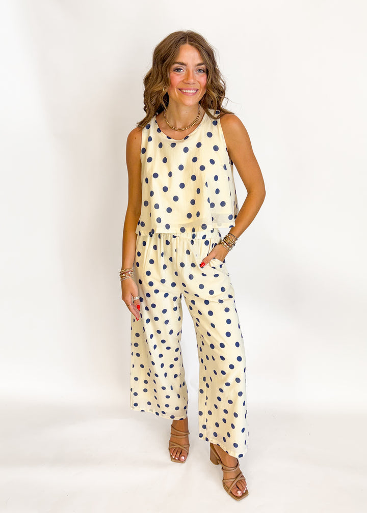 Woman wearing a cream and navy polka dot matching set 