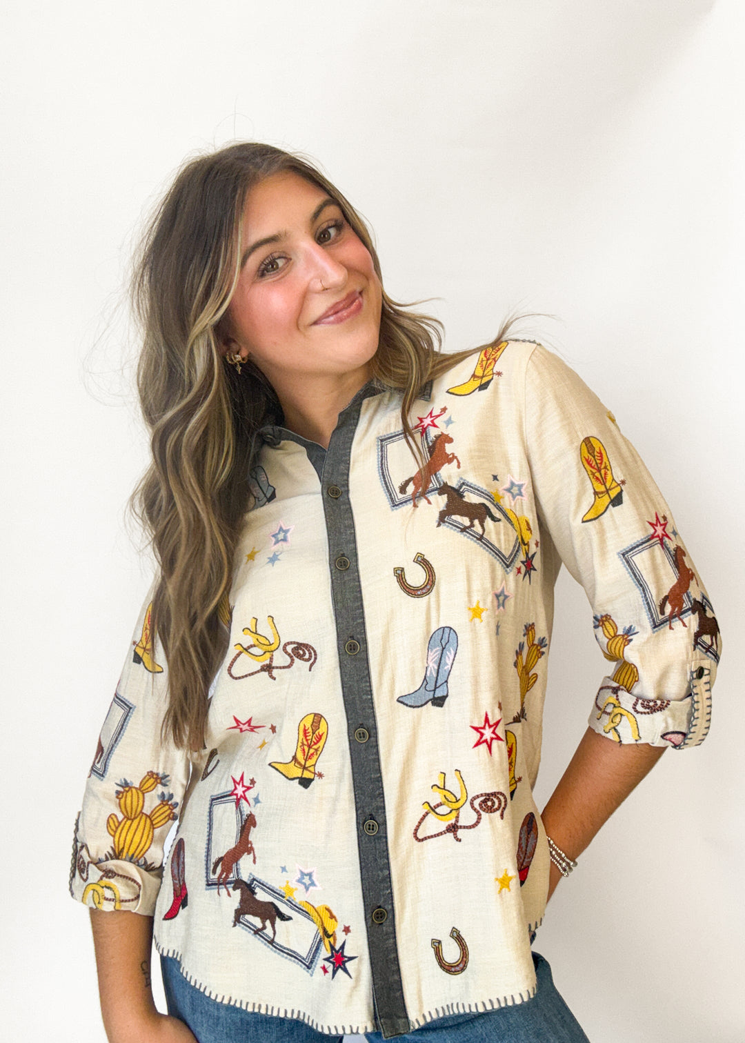 Woman wearing a cream western pattern button down top