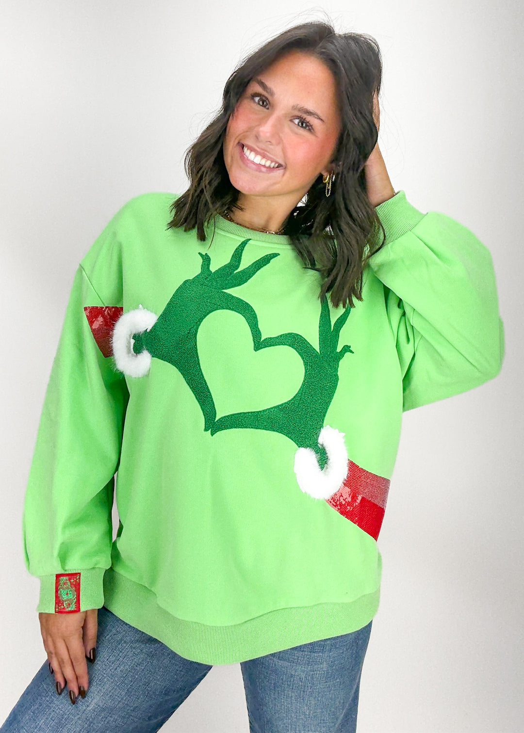Person wearing a green sweater with a heart 