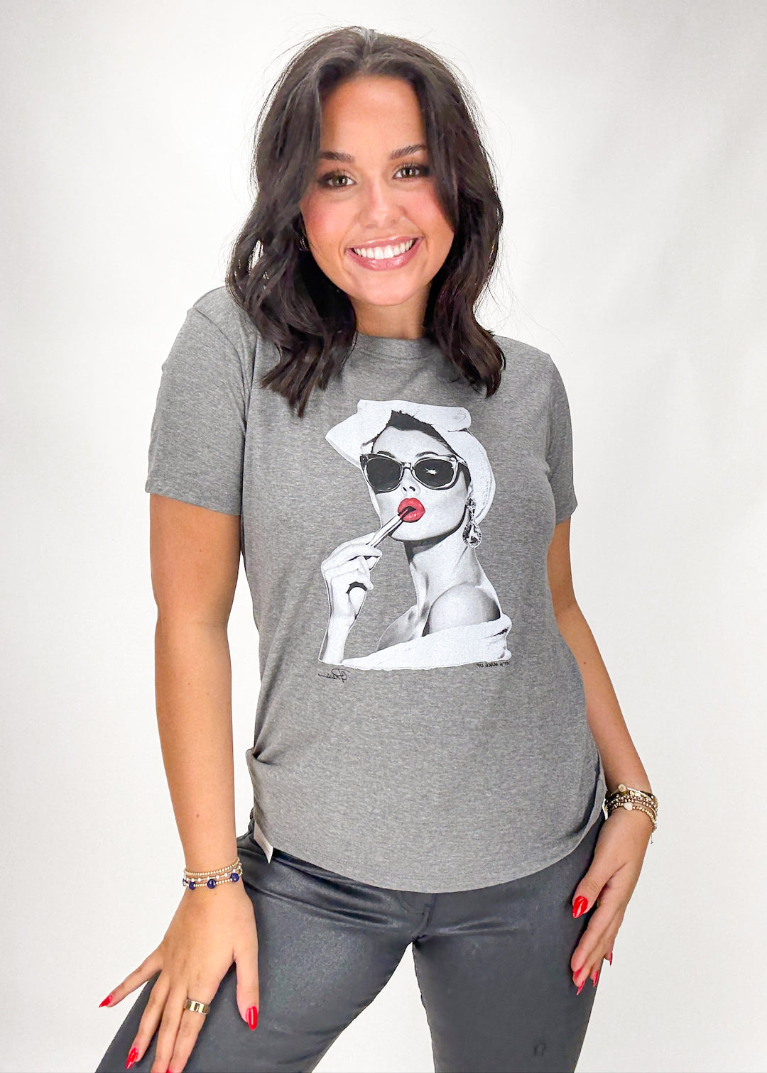 Woman wearing a gray t-shirt with a graphic design on a white background