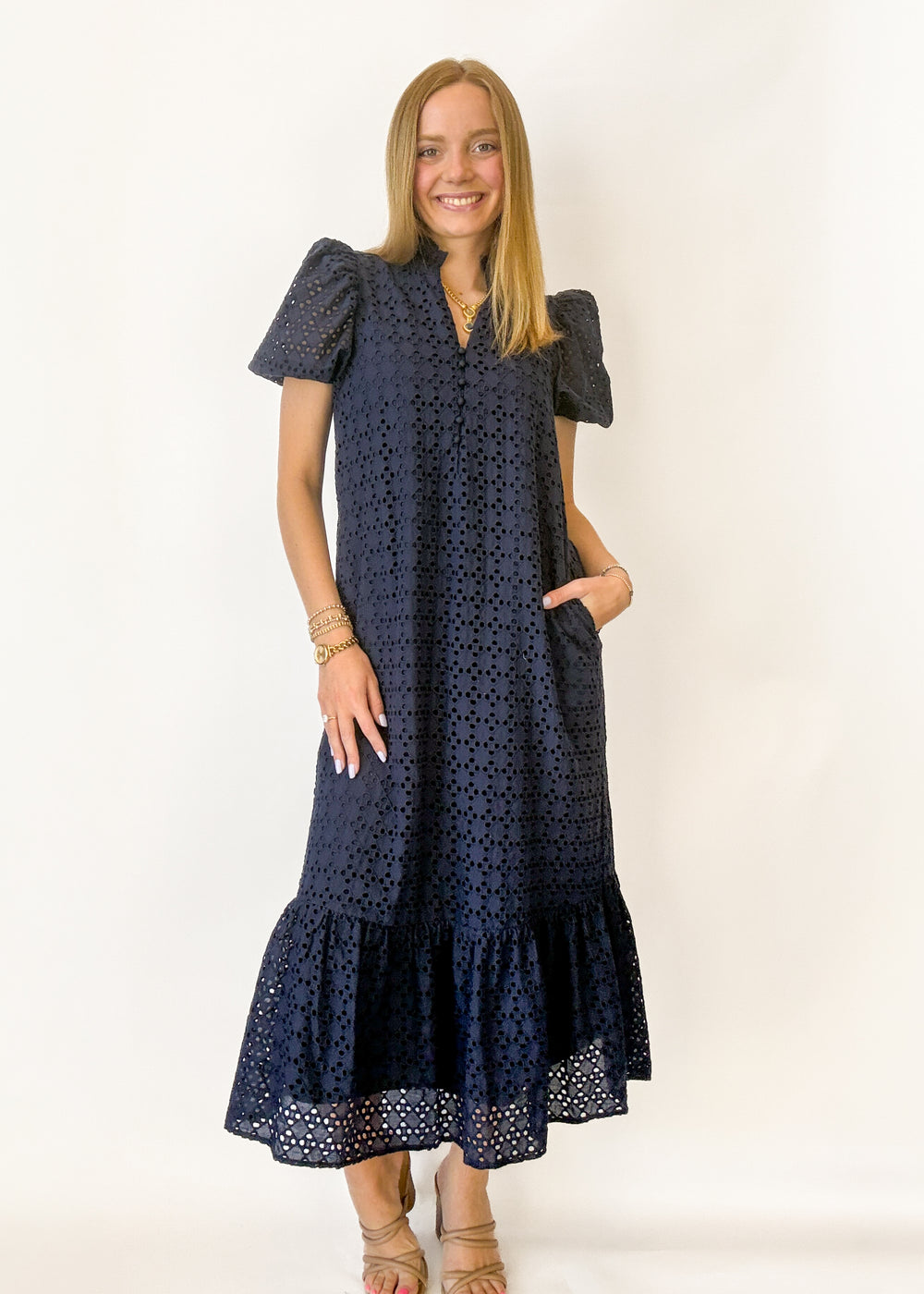 Woman wearing a navy blue dress with a white background
