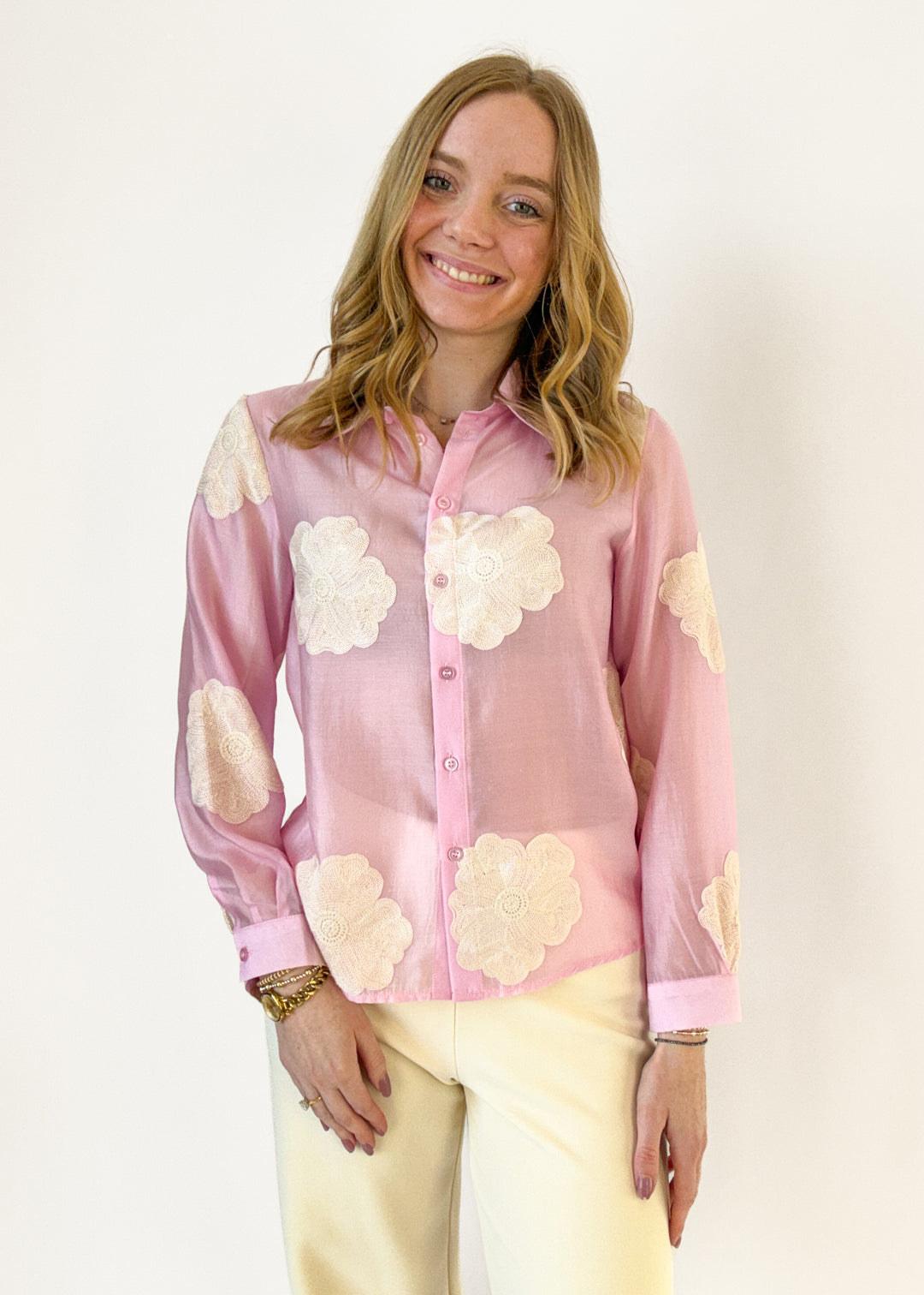 Woman wearing a pink floral blouse with a plain background