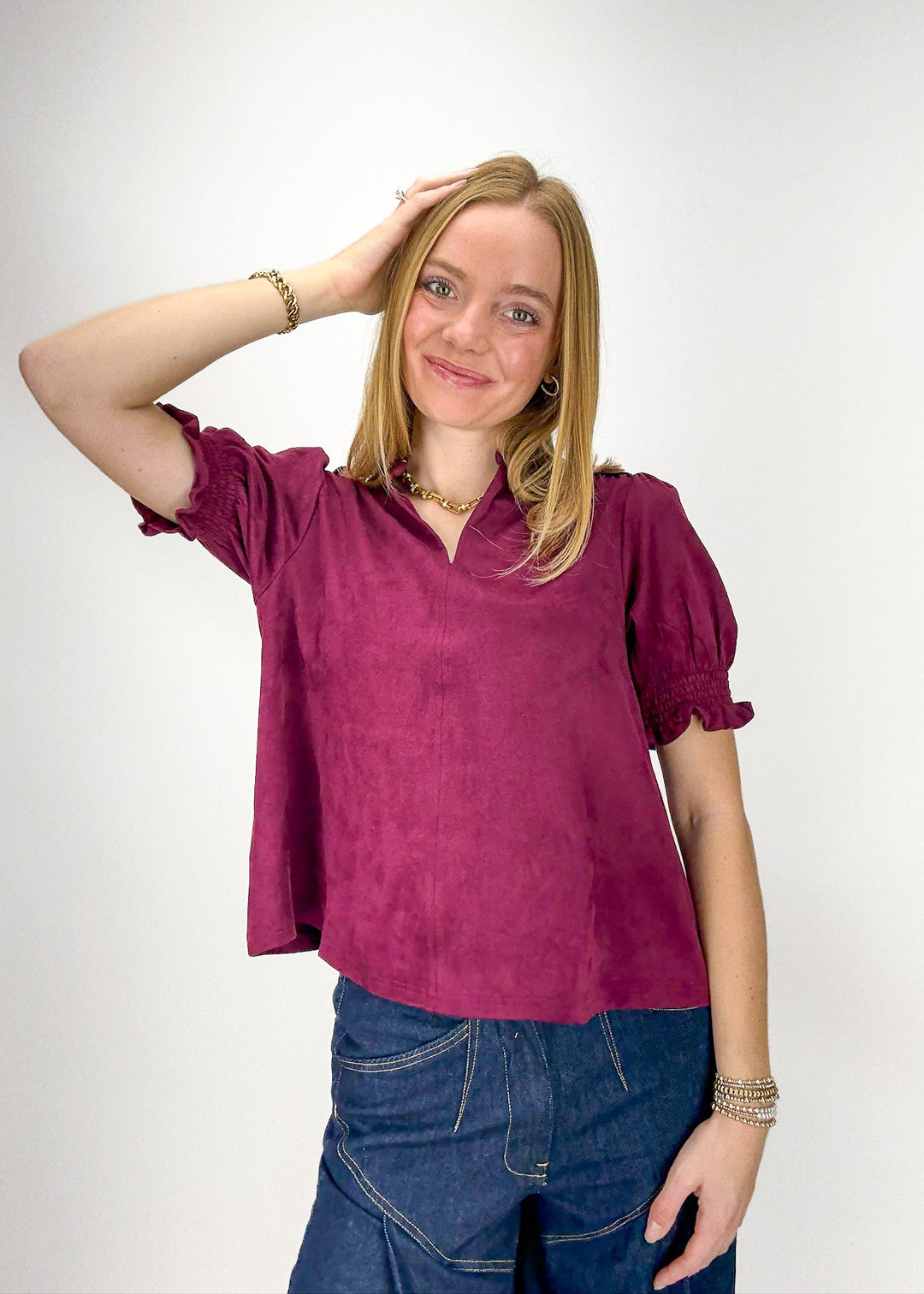Woman wearing a purple blouse and blue jeans 