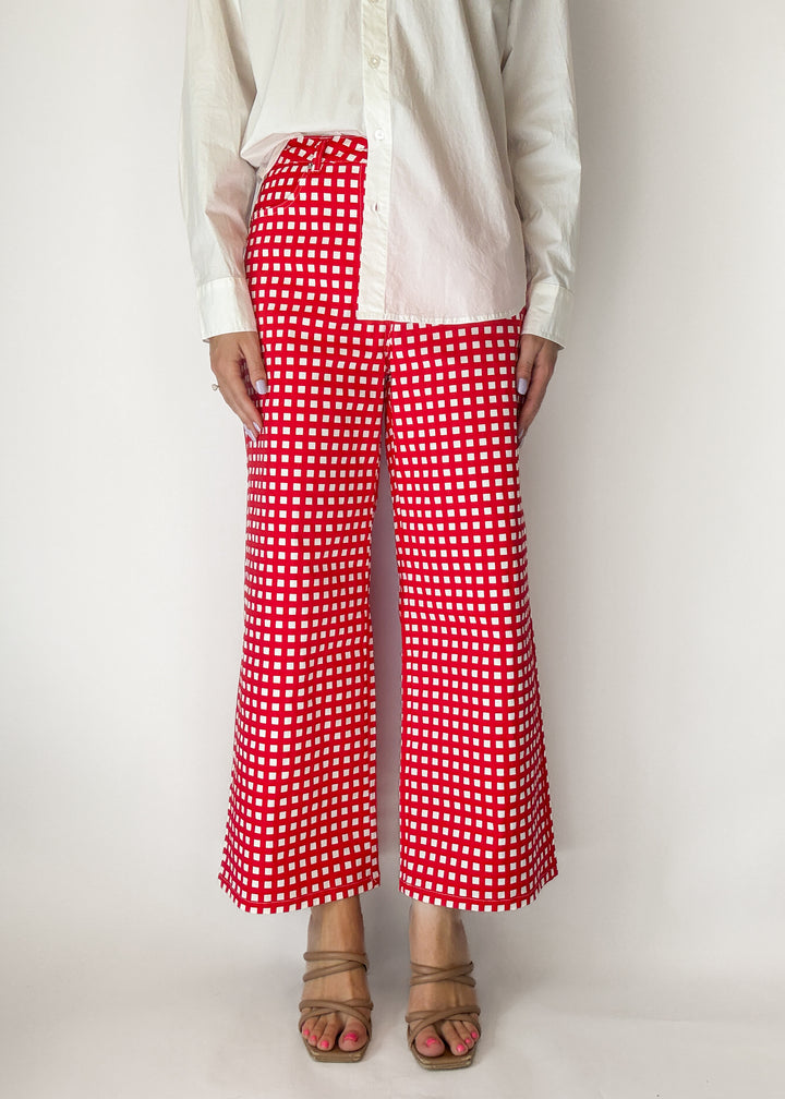 Person wearing red and white checkered pants on a plain background