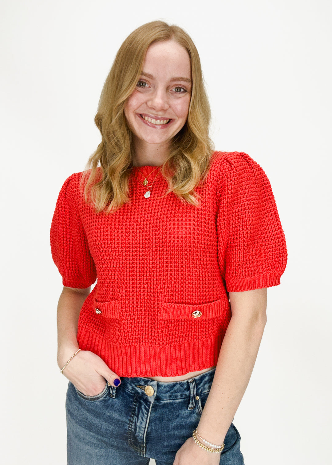 red waffle knit top with puff sleeves and front pocket accents