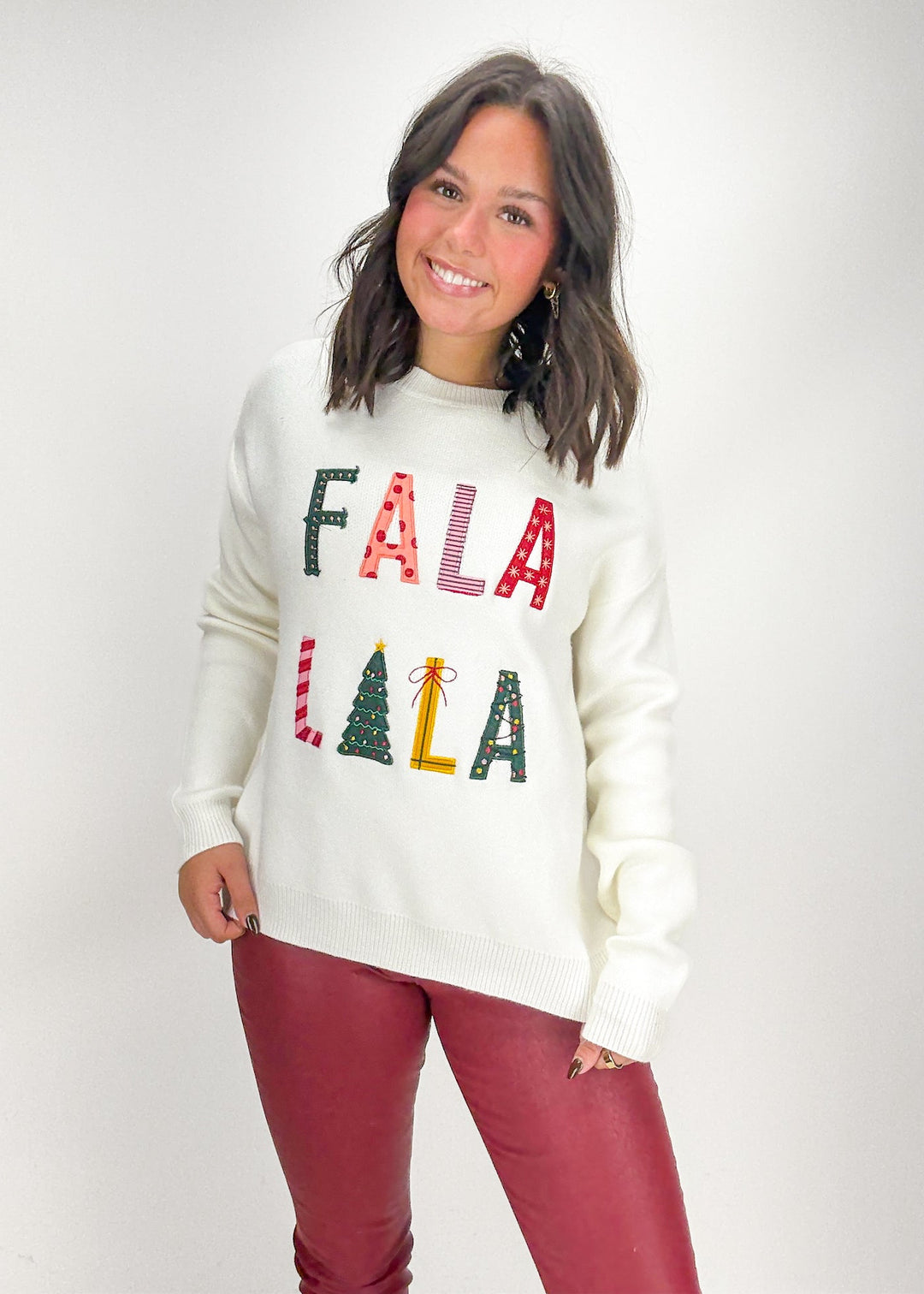Woman wearing a white sweater with colorful text and graphics 