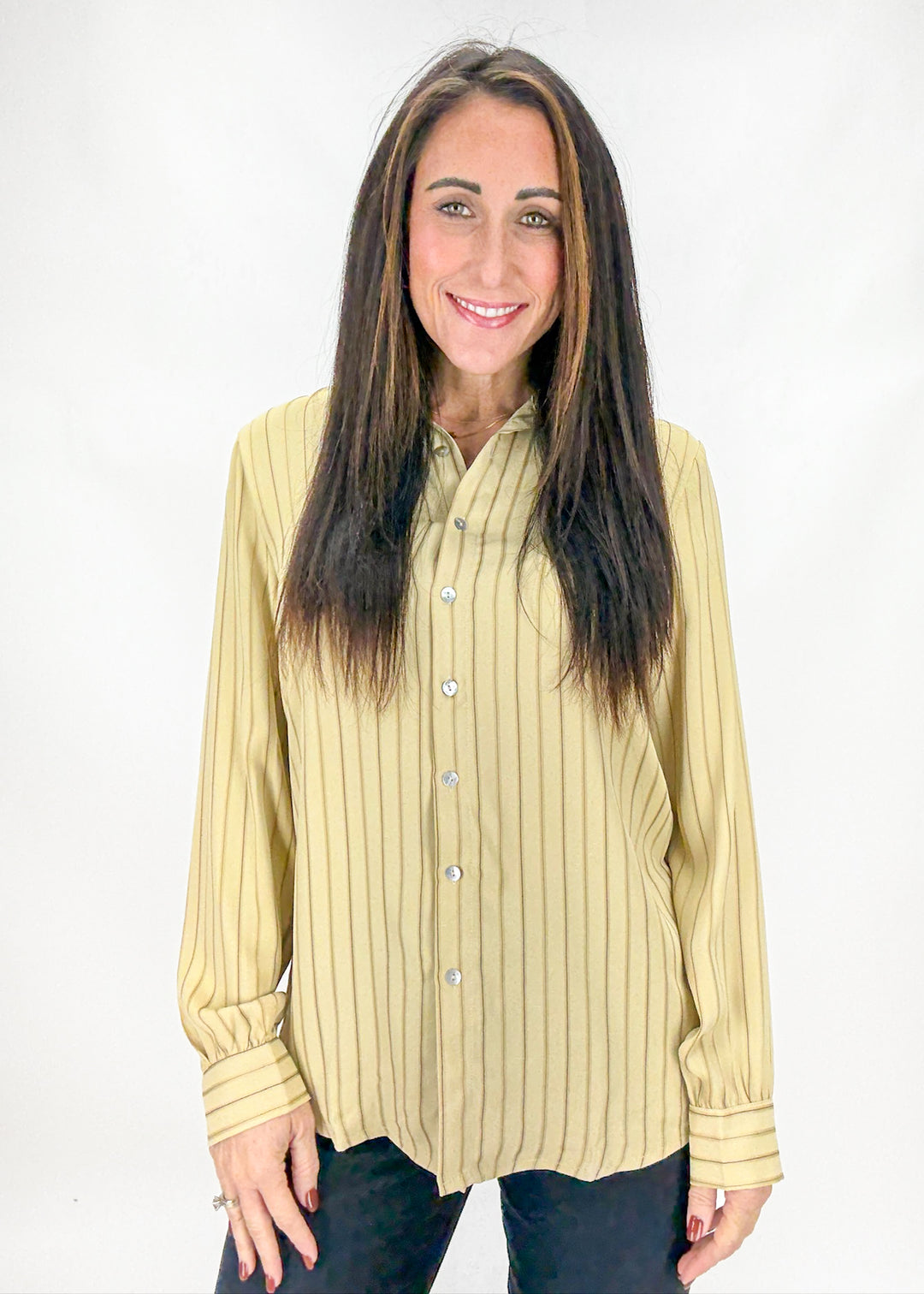 Woman wearing a light yellow striped shirt against a white background